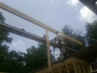 Carpenter setting a ridge beam over a new addition frame — Ice Dam Removal by Roofing Brothers in Oceanport