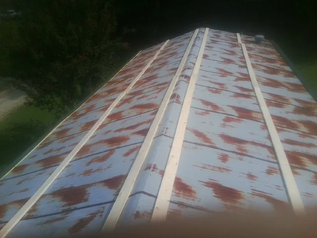 Rusted metal roof panels with new wood purlins before replacement — Storm Damage Roof Repair in Oceanport by Roofing Brothers