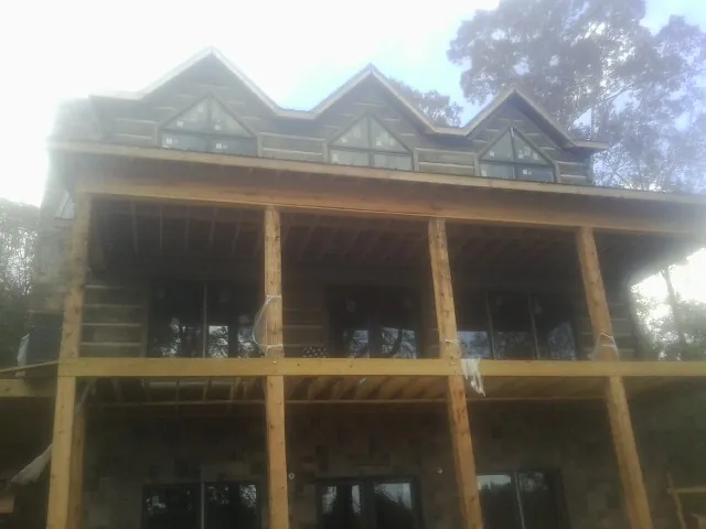 Dormers and porch framing on a large log home under construction — Roof Coating work by our crew in Oceanport