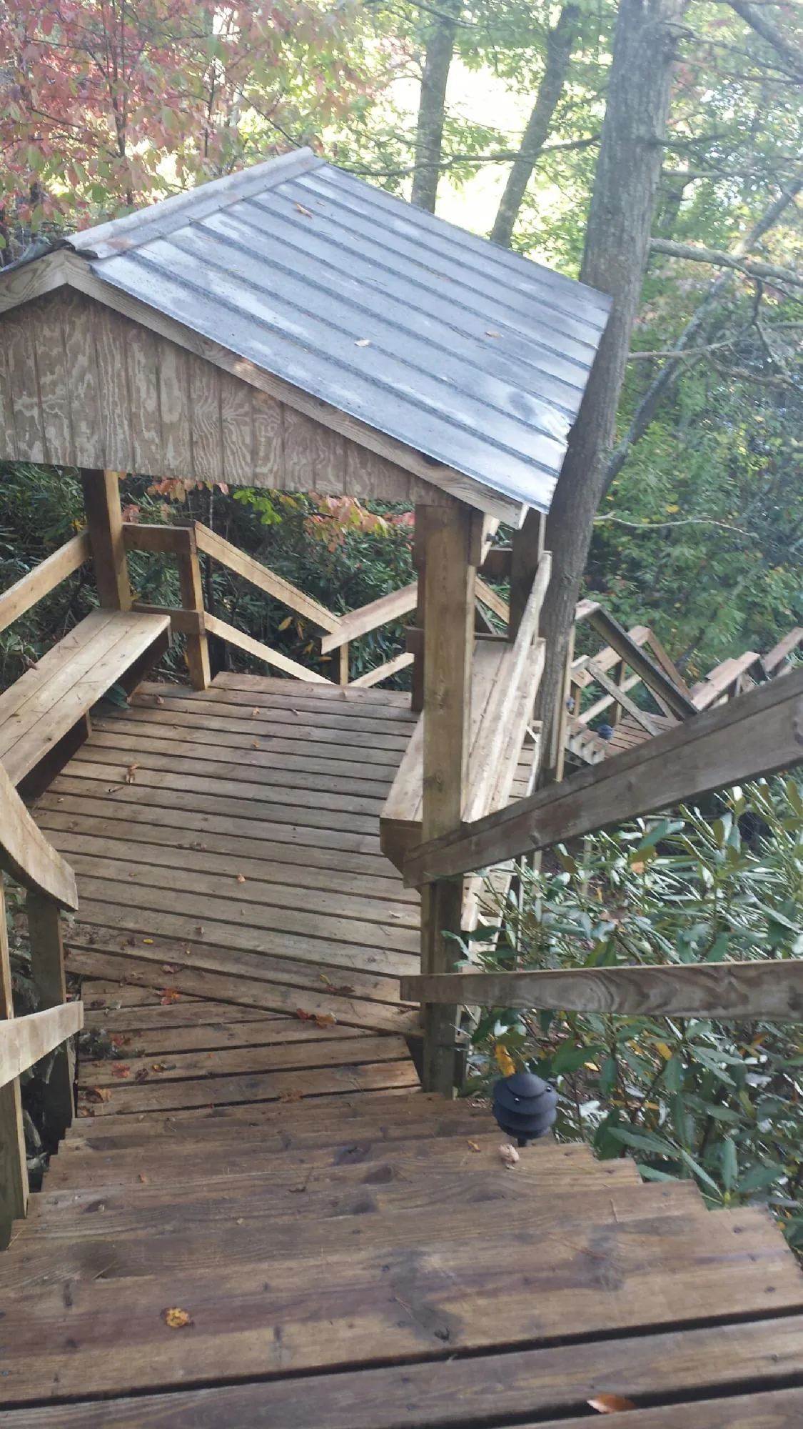 Metal roofed shelter over wooden steps on a wooded walkway — Skylight Repair & Installation work by our crew in Oceanport