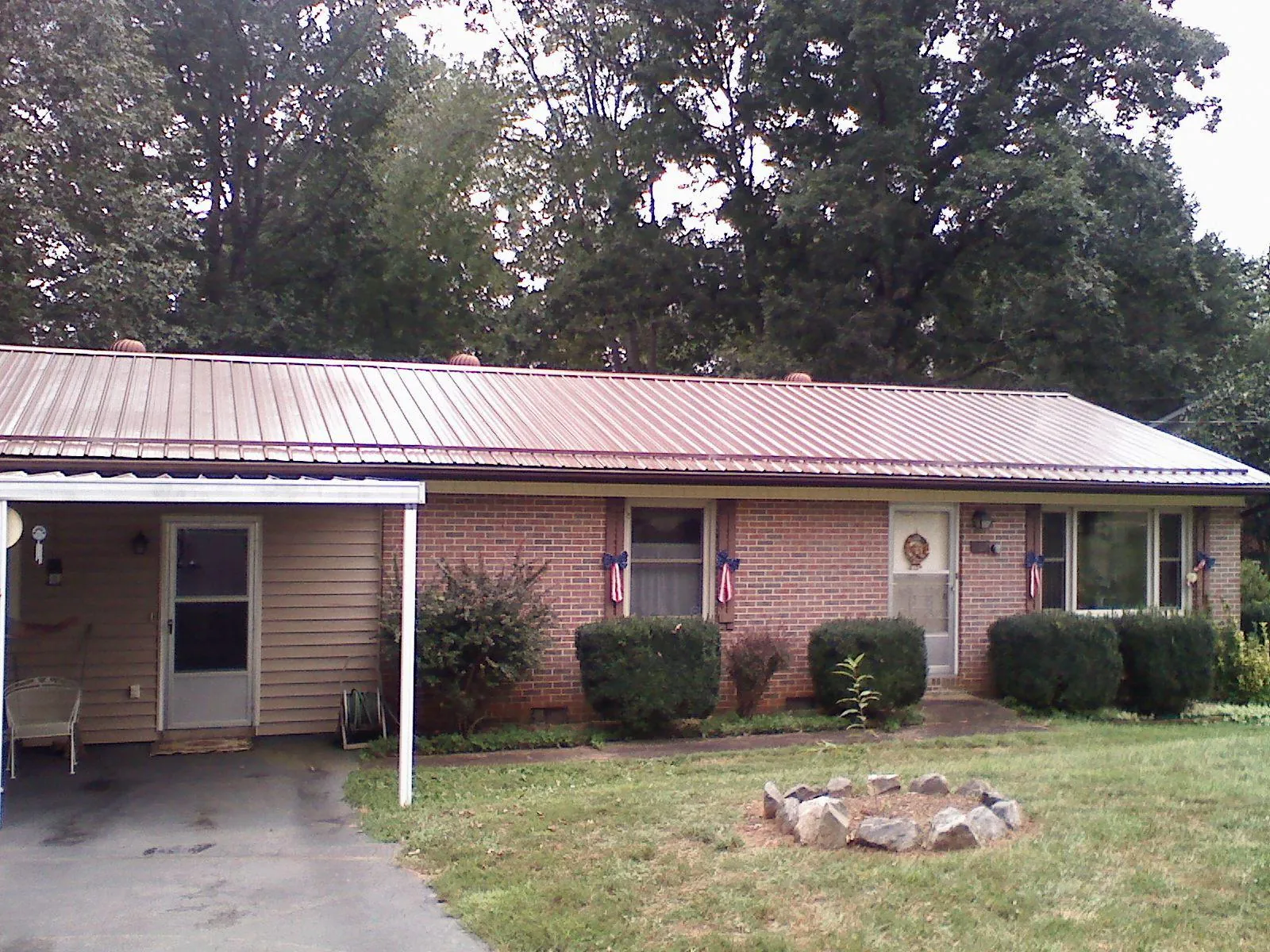 Bronze metal roof and carport on a brick ranch home — Roof Repair work by our crew in Oceanport